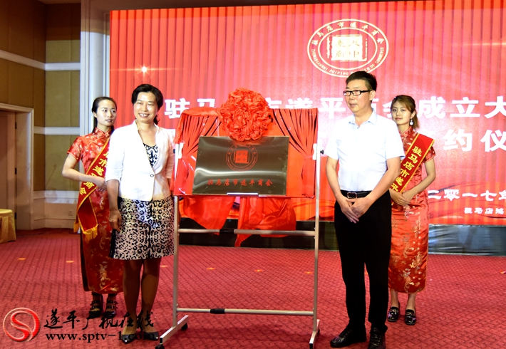 图为:遂平县委书记何冬和驻马店市遂平商会会长王海洲为驻马店市遂平商会揭牌。