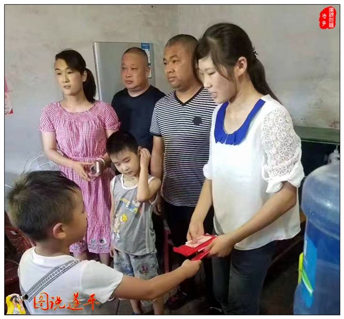 图为:小爱心志愿者来把爱心捐款递到任青云的手中。