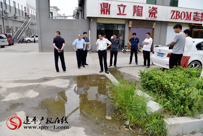 上图:县委副书记尹永彪与相关部门负责人在城南建材市场南门外查看积水问题,当即责成市场发展局限时解决。